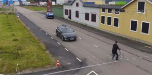 Image of a car approaching intersection with pretend houses behind it