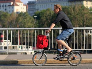 A man riding a Brompton folding bike